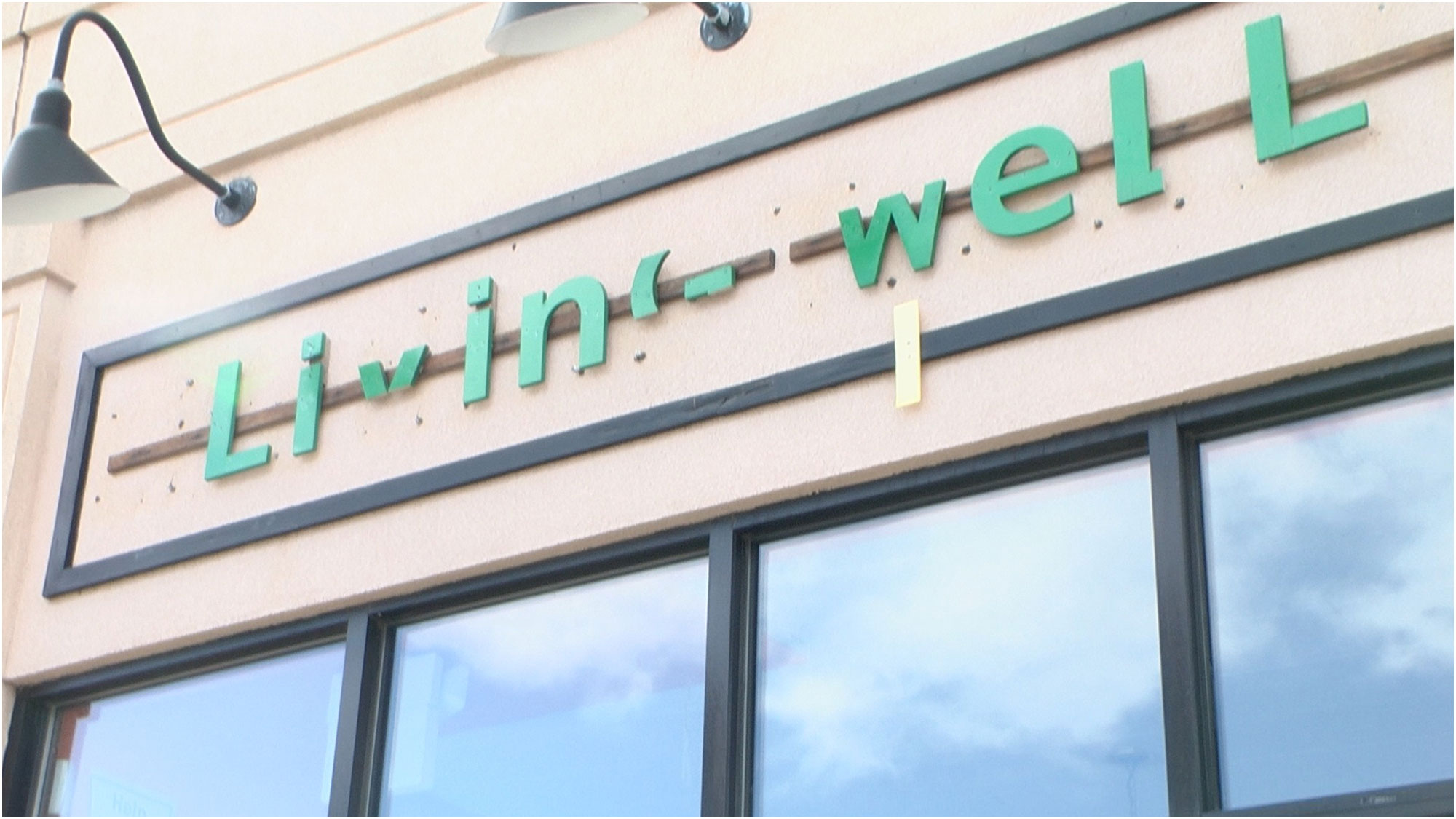 image of a sign for Living Well, a business in Somerville, MA